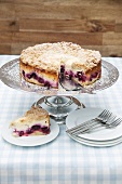 Crumble-topped quark cake with blackberries, one slice cut