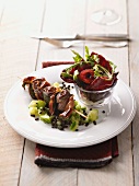 Veal kebabs on vegetables with a green salad