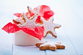 Gingerbread stars garnished with icing in a wooden box and around it