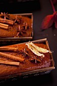 Cinnamon and ginger cake garnished with cinnamon sticks and dried leaves