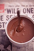 Schokoladenmousse in einem Pappbecher auf einer Zeitung