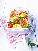Tortellini casserole with bacon, tomatoes and rocket
