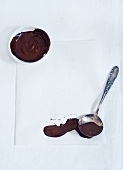 Melted chocolate in a small bowl and on a spoon