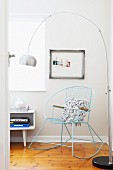 Pale blue, metal rocking chair and arc lamp in corner