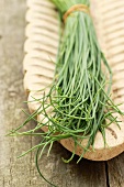 A bunch of chives in a wooden serving dish