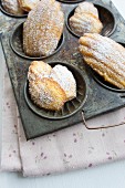 Madeleines in an antique baking tray on a floral napkin