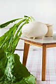 Small white radish with leaves on dolls' house table