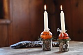 Hand-crafted Advent arrangement of candlesticks made from beakers and oranges stuck with cloves