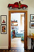 Blick durch Tür mit Holzrahmen ins Kinderzimmer auf blaues Polstersofa