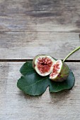 A halved fig on a fig leaf