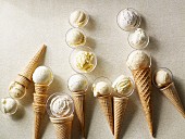 Scoops of vanilla ice cream in wafer cones and glass dishes