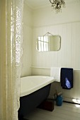 Vintage bathroom with white, wood-clad walls and lace curtain to one side