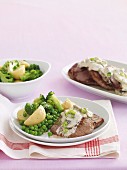 Beef steaks with mushroom sauce and peas