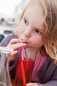Little girl drinking fruit juice