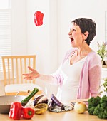 A woman throwing a red pepper in the air