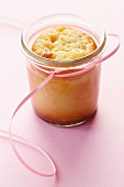 Lemon cake baked in a preserving jar on a pink surface
