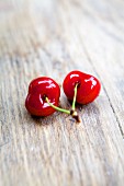 Two sweet cherries on a wooden table