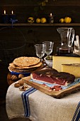 Rustikale Südtiroler Brotzeit mit Rohschinken, Schüttelbrot, Nüssen, Käse und Wein