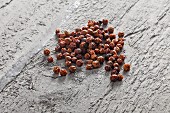 Red peppercorns on grey wood