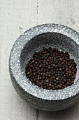 Tellicherry peppercorns in a mortar