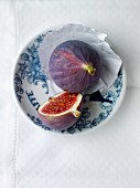 A whole fig and half a fig on a plate