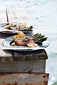Grilled lamb steaks with asparagus on the landing stage