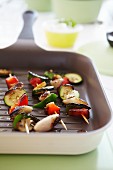 Vegetable skewers of peppers, courgette and onions in a griddle pan