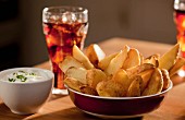 Potato wedges with a dip and a soft drink