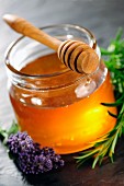 Honey jar with dipper, rosemary and lavender flower
