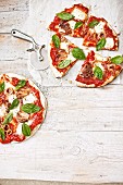 Pizzen mit Tomaten, Mozzarella, Basilikum und gegrillten Baby-Calamari
