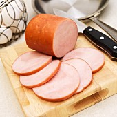 Canadian Bacon with Slices on a Cutting Board with Knife