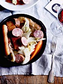 A meat platter with pickled cabbage, smoked sausage and pork