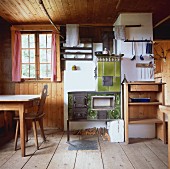 Rustic kitchen-utility room with tiled stove and broad, rough floorboards