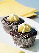 Cupcakes with dark chocolate coating and white chocolate topping