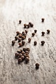 Black peppercorns on a grey surface