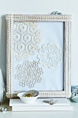 Collage of crocheted doilies in picture frame decorated with lace trim