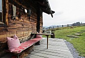 Rustic bench in front of Alpine cabin
