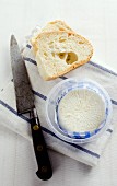 Goat's cheese in a small dish with bread and a knife