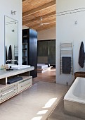 Elegant bathroom with floor-to-ceiling doorway and view into bedroom with separate dressing room