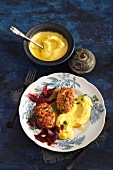 Kalbsbutterschnitzel (minced veal patties fried in butter then braised) with onions cooked in red wine, and polenta (Viennese cuisine)
