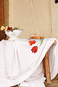 Tablecloth embroidered with floral motif on wooden table