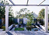 Terrace with pergola in front of modern, landscaped garden with pool