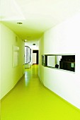Long corridor with green floor and ribbon window to adjacent room