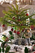 Festively decorated table with miniature Christmas tree and figurine