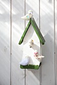 Wooden birdhouse with hand-crafted birds made from undyed wool felt