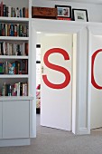 Large red letters decorating interior doors surrounded by fitted shelving