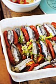 Bread-stuffed anchovies and tomatoes in a baking dish