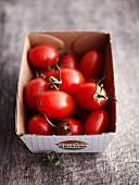 Small plum tomatoes in a cardboard box