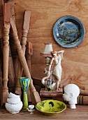 Small china table lamp with figurine of woman, painted plate and sculpture of child's head; turned wooden table legs leaning in corner
