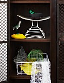 Metal ornaments - bird cage, wire duck and bird figurine on yellow stone in old locker with wire mesh door